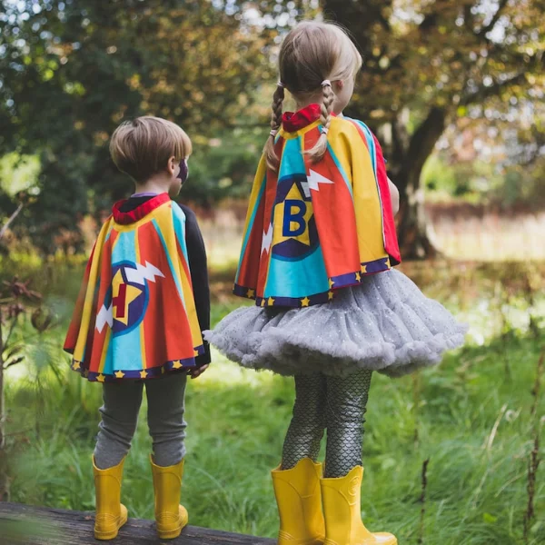Two children wearing personalised superhero capes