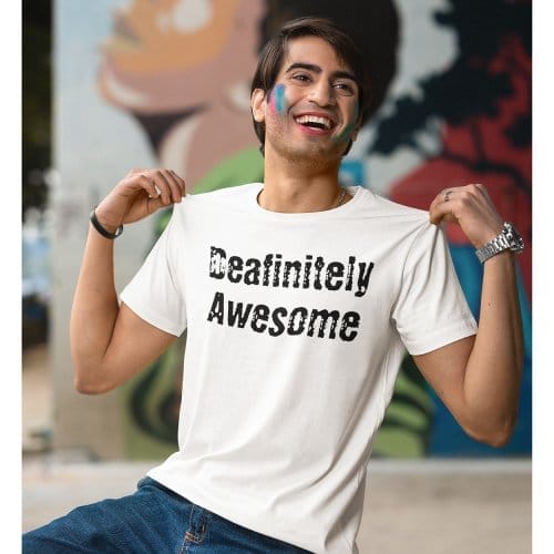 A man waering a white t-shirt, holding it up at each shoulder, The T-shirt has the words on it'deafinitely awesome'
