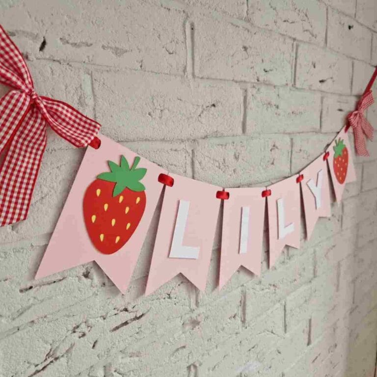 pink bunting, with childs name in white in centre and a strawberry either side
