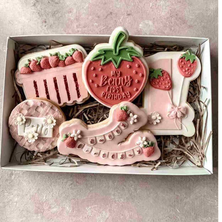 biscuits that have been decorated for a 'Berry 1st birthday' with a Strawberry theme