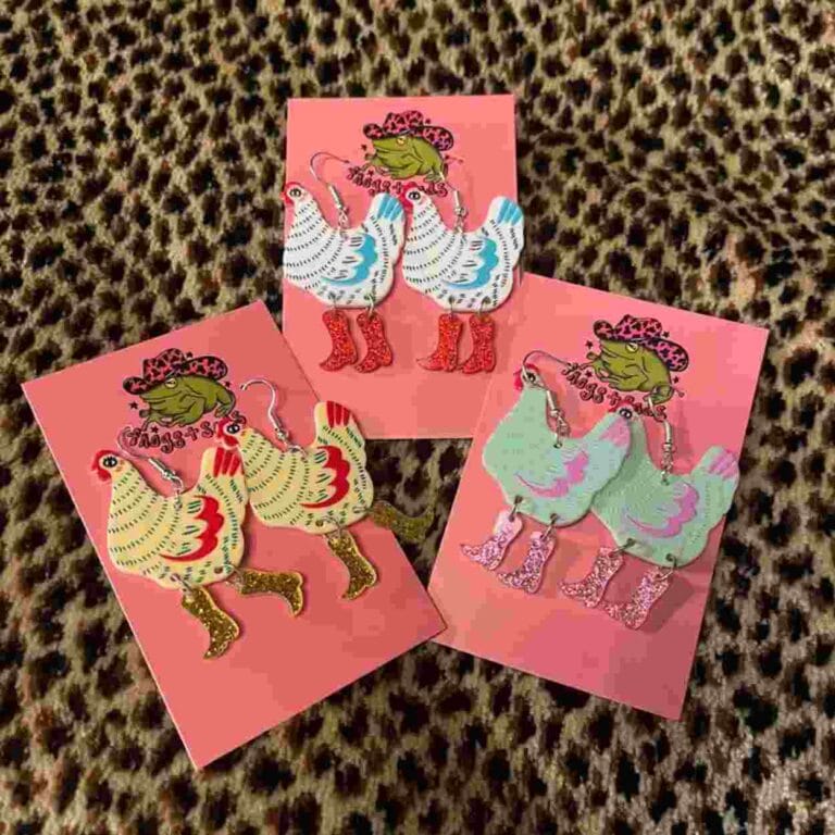 A set of 3 different earrings that all feature chickens in boots