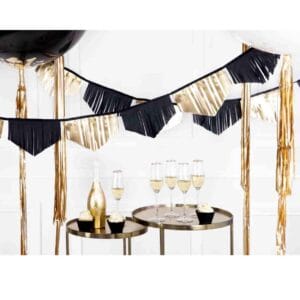 Gold and black fringe garland hanging across a 1920s themed party wall